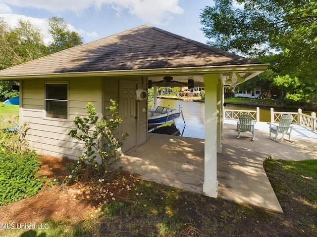 view of patio / terrace with ceiling fan, a dock, and a water view