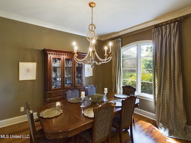 dining space with a chandelier, dark wood-type flooring, and ornamental molding