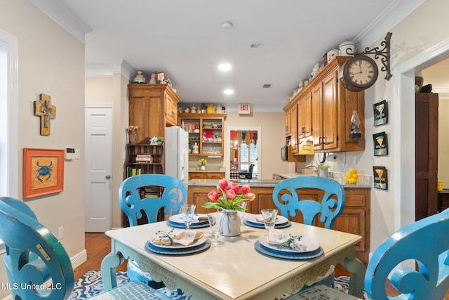 dining space featuring hardwood / wood-style flooring and crown molding