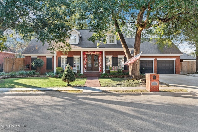 cape cod home with a porch, a garage, and a front lawn