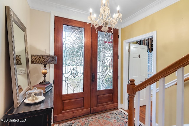 foyer with hardwood / wood-style floors, crown molding, french doors, and a chandelier