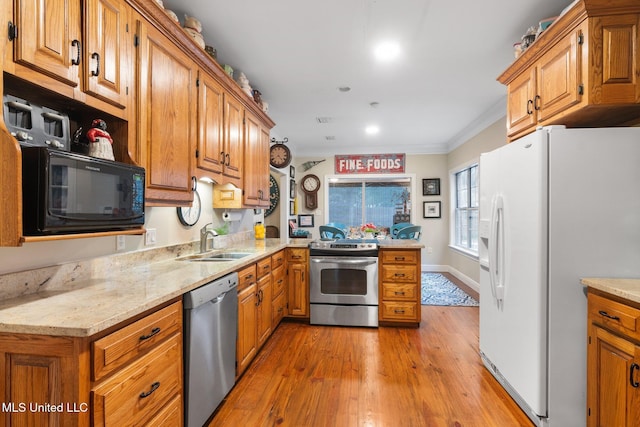 kitchen with light stone countertops, sink, light wood-type flooring, appliances with stainless steel finishes, and ornamental molding