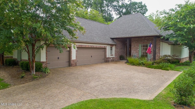 view of front facade featuring a garage, driveway, brick siding, and roof with shingles