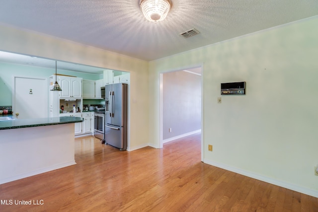 419 Cove Dr, Biloxi, MS 39531 - kitchen featuring appliances with stainless steel finishes, white cabinets, visible vents, decorative light fixtures, and light wood-style floors