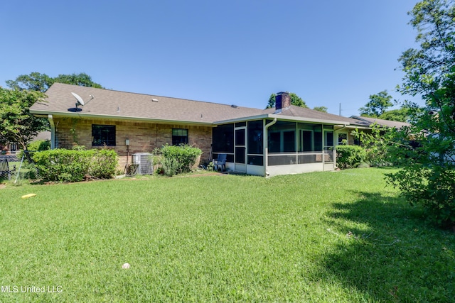419 Cove Dr, Biloxi, MS 39531 - rear view of house with a chimney, a lawn, brick siding, central air condition unit, and a sunroom