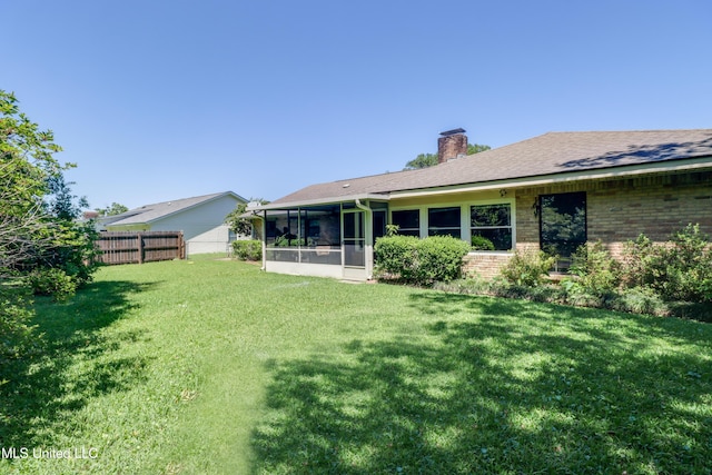 419 Cove Dr, Biloxi, MS 39531 - back of property with a chimney, a yard, brick siding, fence, and a sunroom
