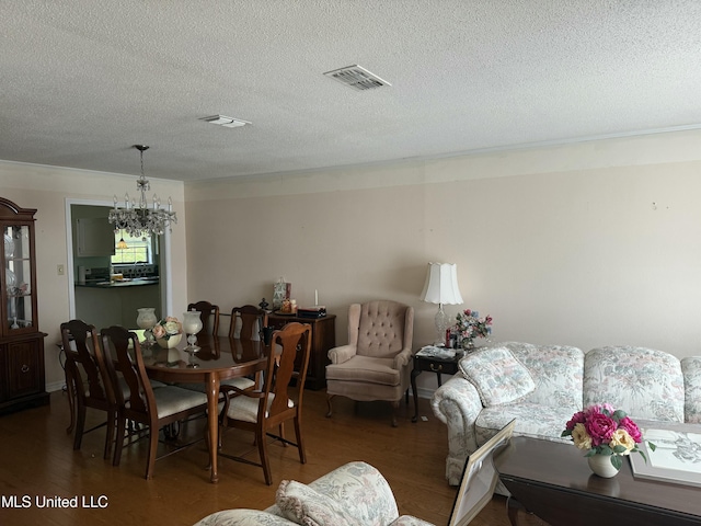 419 Cove Dr, Biloxi, MS 39531 - dining area with a chandelier, visible vents, a textured ceiling, and wood finished floors