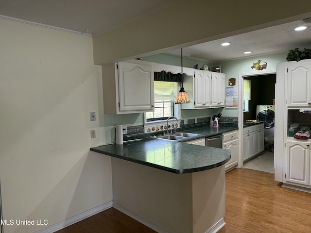 419 Cove Dr, Biloxi, MS 39531 - kitchen featuring a sink, washer / clothes dryer, a peninsula, ornamental molding, and dark countertops