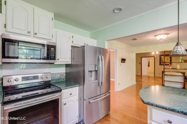 419 Cove Dr, Biloxi, MS 39531 - kitchen with ornamental molding, white cabinets, and appliances with stainless steel finishes
