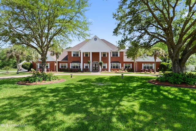exterior space with brick siding and a yard