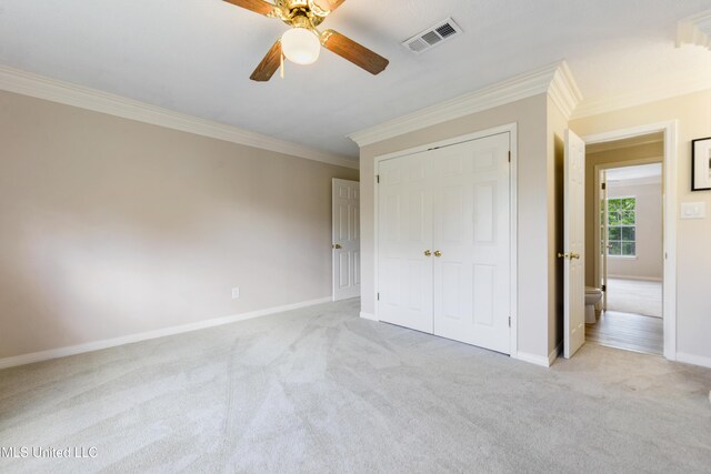 unfurnished bedroom with crown molding, baseboards, visible vents, and carpet