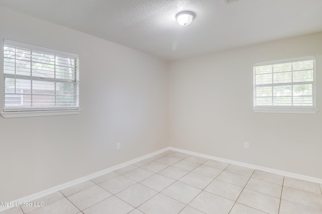 1302 Parktown Dr, Ocean Springs, MS 39564 - spare room with light tile patterned floors, a textured ceiling, plenty of natural light, and baseboards