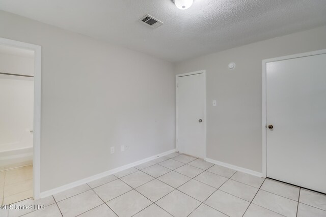 1302 Parktown Dr, Ocean Springs, MS 39564 - unfurnished bedroom with a textured ceiling, baseboards, visible vents, and light tile patterned floors