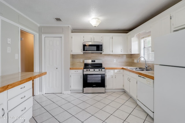 1302 Parktown Dr, Ocean Springs, MS 39564 - kitchen with white cabinets, light tile patterned flooring, a sink, stainless steel appliances, and tasteful backsplash