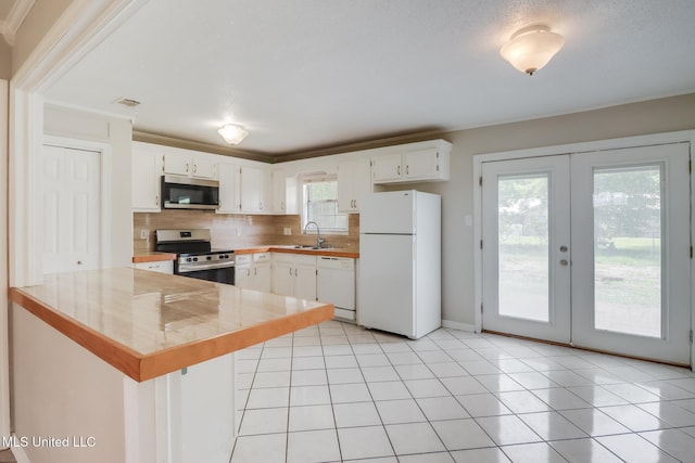 1302 Parktown Dr, Ocean Springs, MS 39564 - kitchen featuring appliances with stainless steel finishes, a sink, french doors, a peninsula, and decorative backsplash