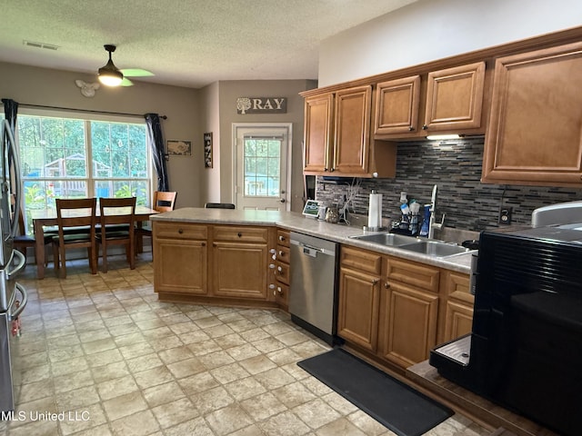 25 Dry Field Rd, Byhalia, MS 38611 - kitchen featuring stainless steel appliances, a peninsula, tasteful backsplash, light countertops, and a textured ceiling
