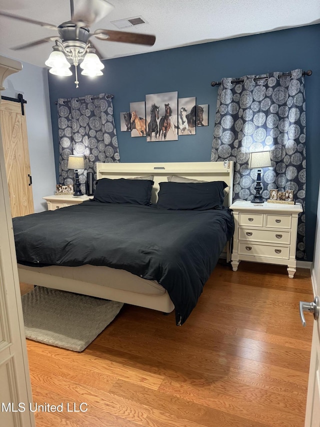 25 Dry Field Rd, Byhalia, MS 38611 - bedroom featuring a barn door, wood finished floors, and ceiling fan