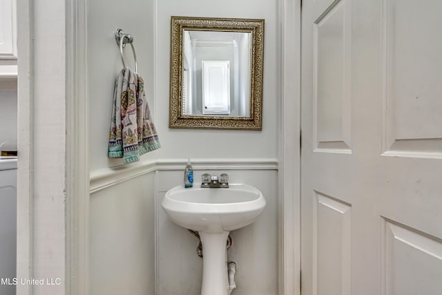 bathroom with a wainscoted wall and a decorative wall