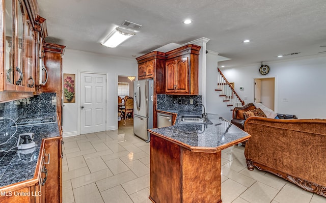 kitchen featuring tile countertops, stainless steel appliances, visible vents, a sink, and a peninsula