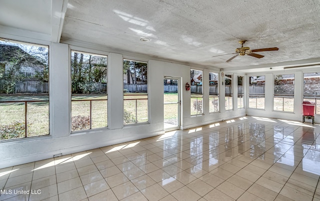 unfurnished sunroom with a ceiling fan and a wealth of natural light