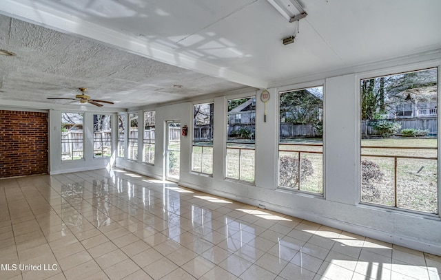 unfurnished sunroom with ceiling fan