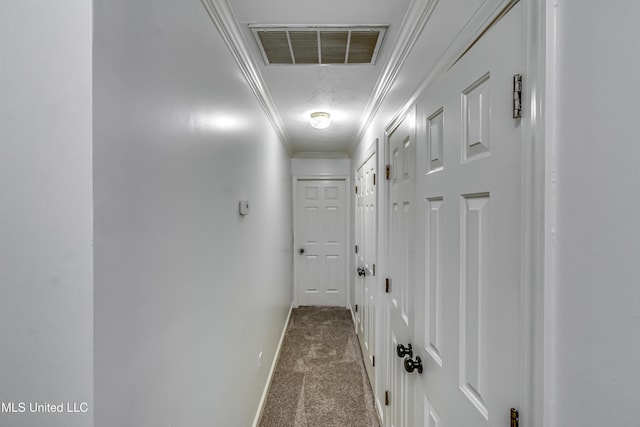 hallway featuring baseboards, carpet flooring, visible vents, and crown molding