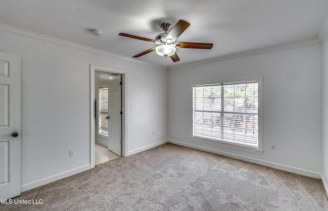 empty room featuring baseboards, carpet flooring, and crown molding