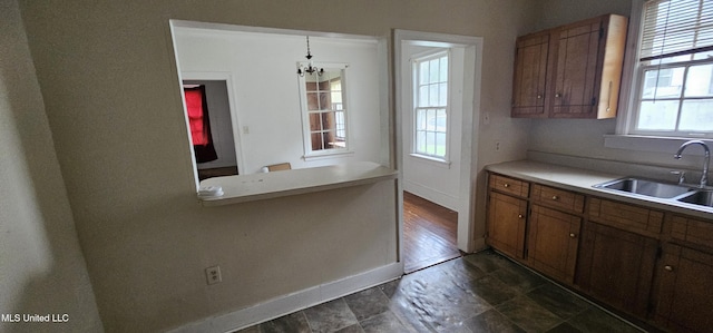 1080 Alta Vista Blvd, Jackson, MS 39209 - kitchen featuring a sink, brown cabinets, baseboards, a chandelier, and light countertops