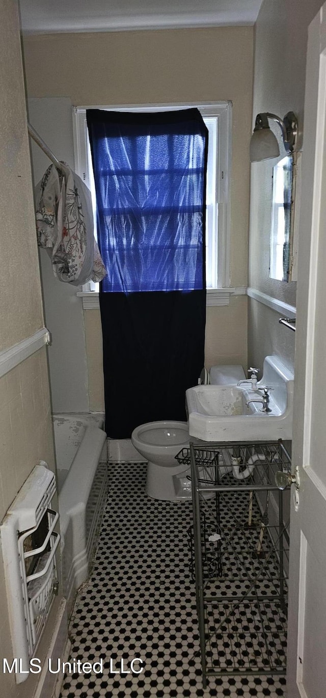 1080 Alta Vista Blvd, Jackson, MS 39209 - bathroom featuring a bath, toilet, tile patterned floors, and ornamental molding