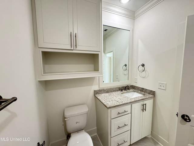 bathroom with toilet, ornamental molding, and vanity