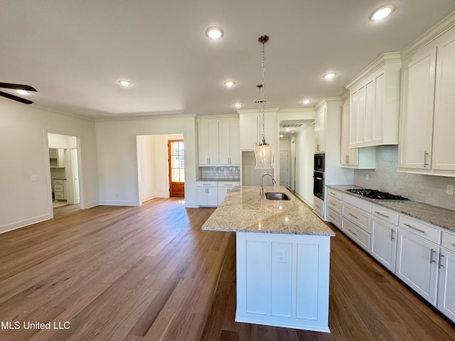 kitchen featuring white cabinetry, gas cooktop, and a kitchen island with sink