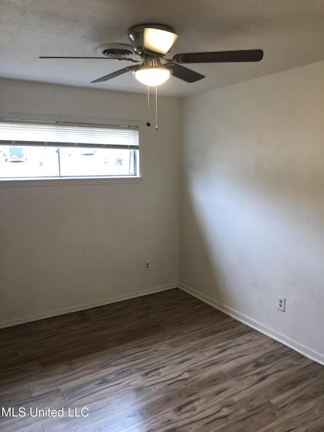 unfurnished room with dark wood-type flooring and ceiling fan