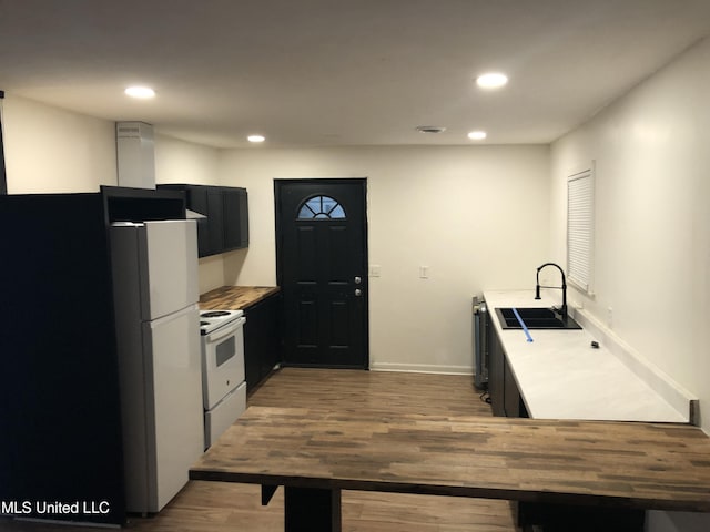 kitchen with sink, white appliances, and dark wood-type flooring