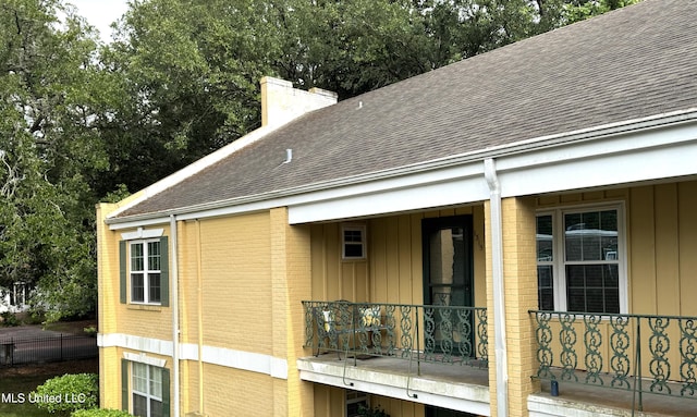 3310 Washington Ave Unit 1315, Pascagoula, MS 39581 - view of side of home with roof with shingles, brick siding, a chimney, and board and batten siding