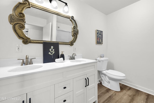 bathroom featuring wood-type flooring, vanity, and toilet