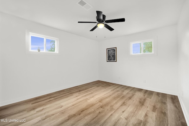 empty room featuring ceiling fan, light hardwood / wood-style floors, and a healthy amount of sunlight