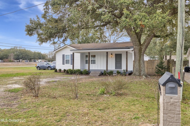 ranch-style home featuring a front lawn and covered porch