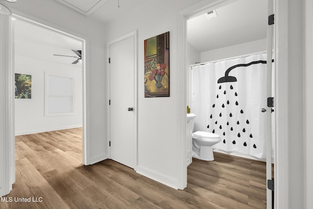 bathroom featuring toilet, curtained shower, and wood-type flooring