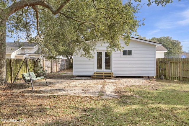 rear view of house featuring a lawn and an outbuilding