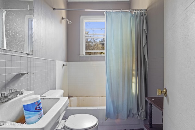 bathroom featuring shower / bathtub combination with curtain, toilet, and tile walls