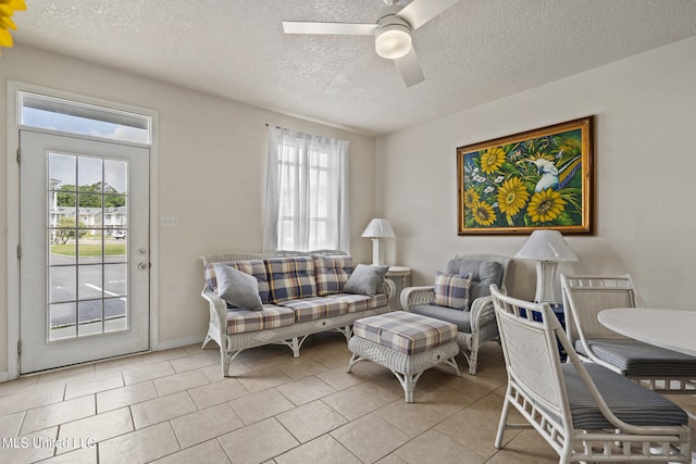 living room featuring a textured ceiling, ceiling fan, light tile patterned flooring, and a wealth of natural light