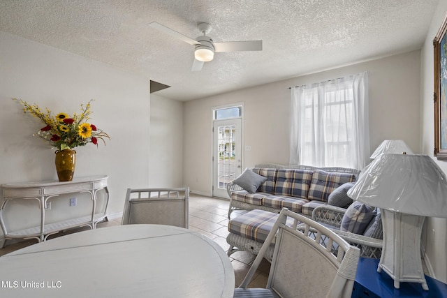 tiled living room with a textured ceiling and ceiling fan