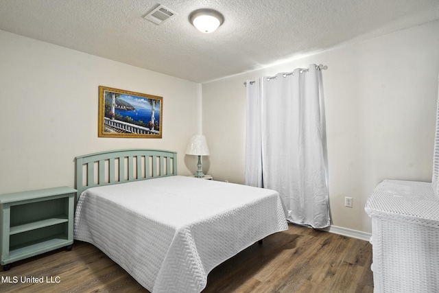 bedroom with a textured ceiling and dark hardwood / wood-style flooring