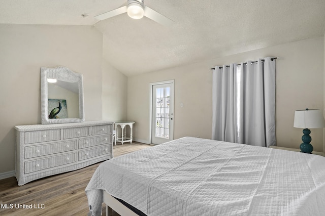 bedroom with ceiling fan, a textured ceiling, lofted ceiling, and hardwood / wood-style floors