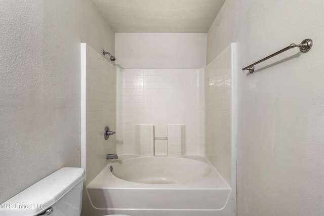 bathroom with toilet and tiled shower / bath