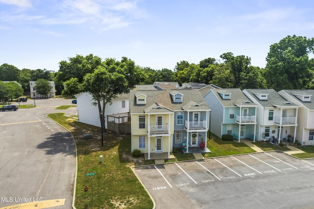 multi unit property featuring a front yard and a balcony