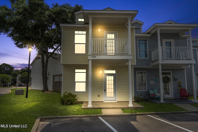 view of front of home featuring a yard and a balcony