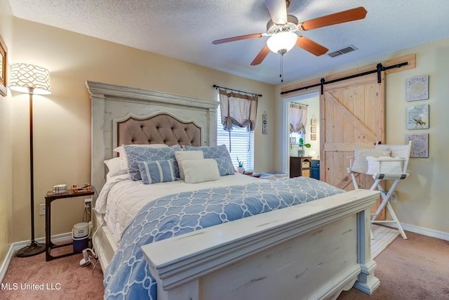 7505 Martin Ct, Ocean Springs, MS 39564 - carpeted bedroom featuring a barn door, baseboards, ceiling fan, and a textured ceiling