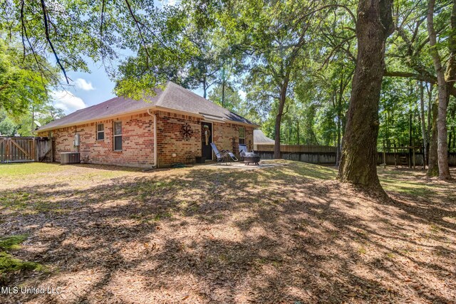 7505 Martin Ct, Ocean Springs, MS 39564 - rear view of property featuring brick siding, central AC, a fenced backyard, and a shingled roof