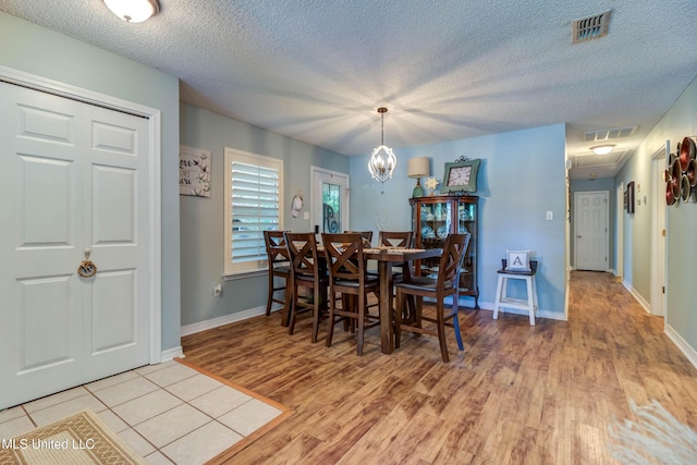 7505 Martin Ct, Ocean Springs, MS 39564 - dining area with light wood finished floors, a textured ceiling, baseboards, and attic access